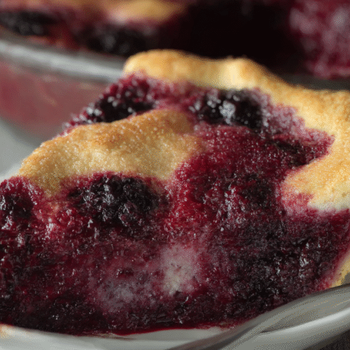 Crazy Crust Berry Pie is a self-crusting dessert made with juicy berries, cinnamon, and a buttery batter that transforms into a golden crust as it bakes.