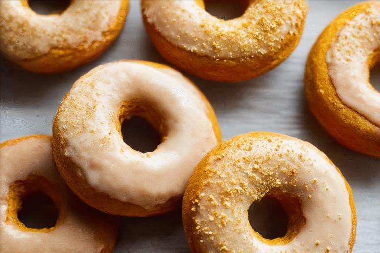 Baked pumpkin donuts with brown sugar icing and walnuts on top
