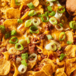Frito Pie Casserole with ground beef, beans, salsa, cheese, and crunchy Fritos in a baking dish.