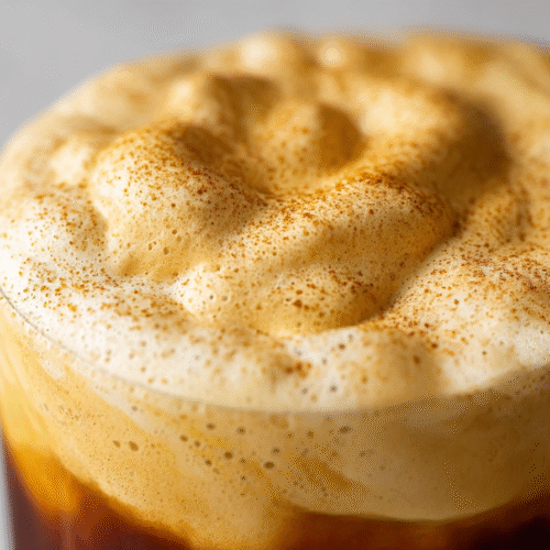 Glass of cold brew topped with homemade pumpkin cream cold foam and pumpkin spice