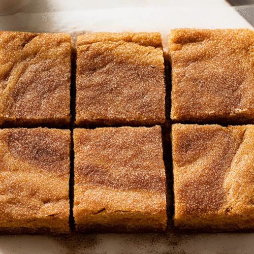 Pumpkin snickerdoodle brownies with cinnamon sugar topping cut into squares
