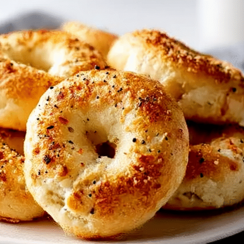 Freshly baked Cottage Cheese Bagel Bites topped with Everything Bagel seasoning on a parchment-lined tray